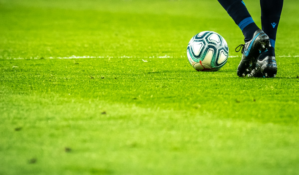 Soccer and football tournament players competing on pitch